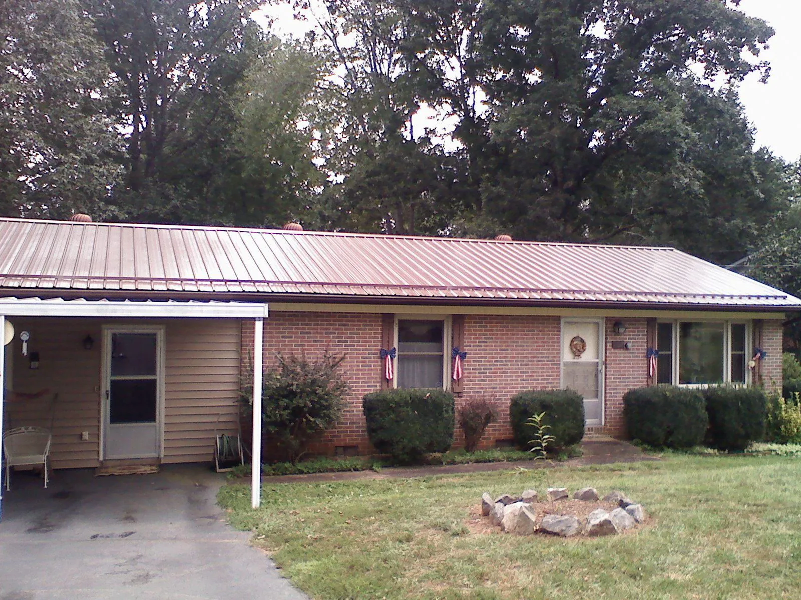Bronze metal roof and carport on a brick ranch home — Roof Repair work by our crew in Glen Cove